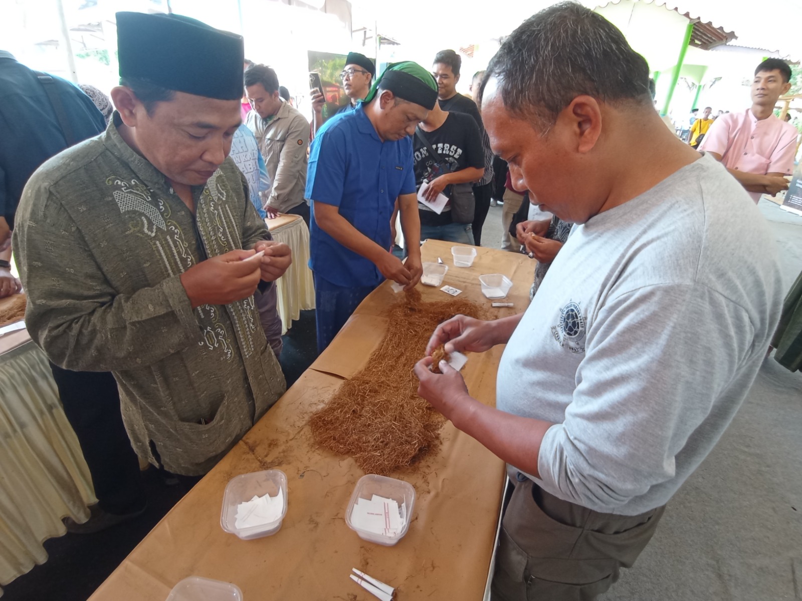 LINTINGAN: Peserta lomba linting tembakau saat berusaha melinting sebanyak mungkin dalam waktu tiga menit. (HILMI/RJ)