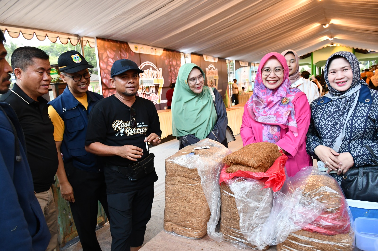 BERJEJER: Ibu Pj Bupati Bondowoso (hijab pink) saat mengunjungi salah satu stand UMKM yang menyediakan berbagai jenis tembakau.
