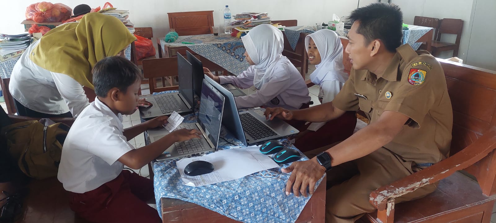 SEMANGAT: Tiga siswa SDN Banjarsari 04, Desa Banjarsari, Kecamatan Bangsalsari saat mengikuti Asesmen Nasional Berbasis Komputer (ANBK) diruang guru. (JUMAI/RJ)