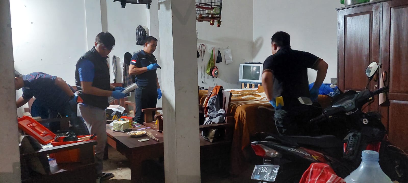 DATANGI LOKASI: Tim Inafis Polres Jember melakukan olah TKP di rumah korban, Perum Baitul Jannati Residence, Lingkungan Jambuan, Kelurahan Antirogo, Kecamatan Sumbersari, Sabtu (2/11). (JUMAI/RJ)