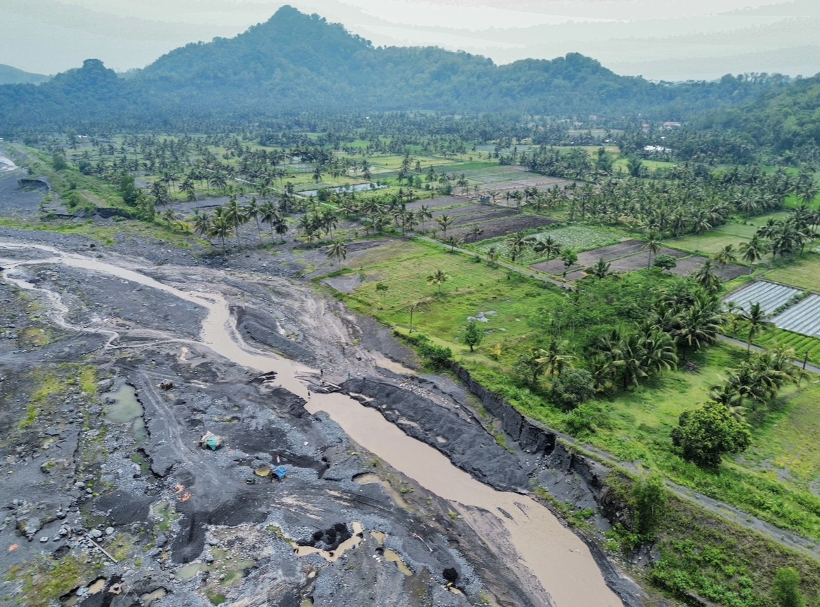 TERKIKIS: Tampilan dari udara aliran sungai Regoyo yang menjadi jalur lahar Gunung Semeru tampak sangat berdekatan dengan pemukiman dan lahan pertanian warga. (MUHAMMAD HASBI/RAME)