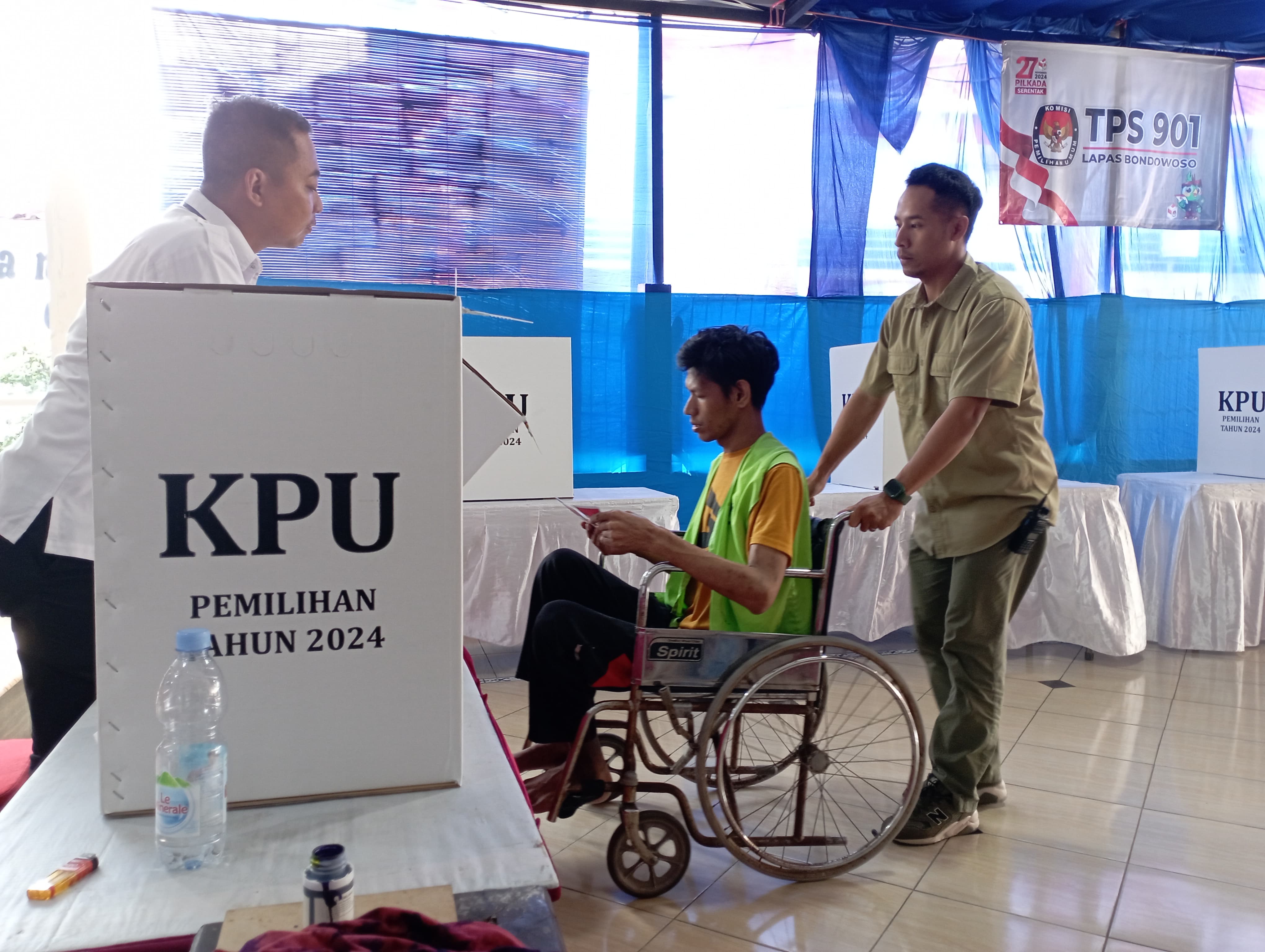 JAMIN TETAP RAHASIA: Warga binaan Lapas Kelas II B Bondowoso yang merupakan disabilitas dibantu untuk menyalurkan hak suara. Dipastikan kerahasiaan tetap terjaga.