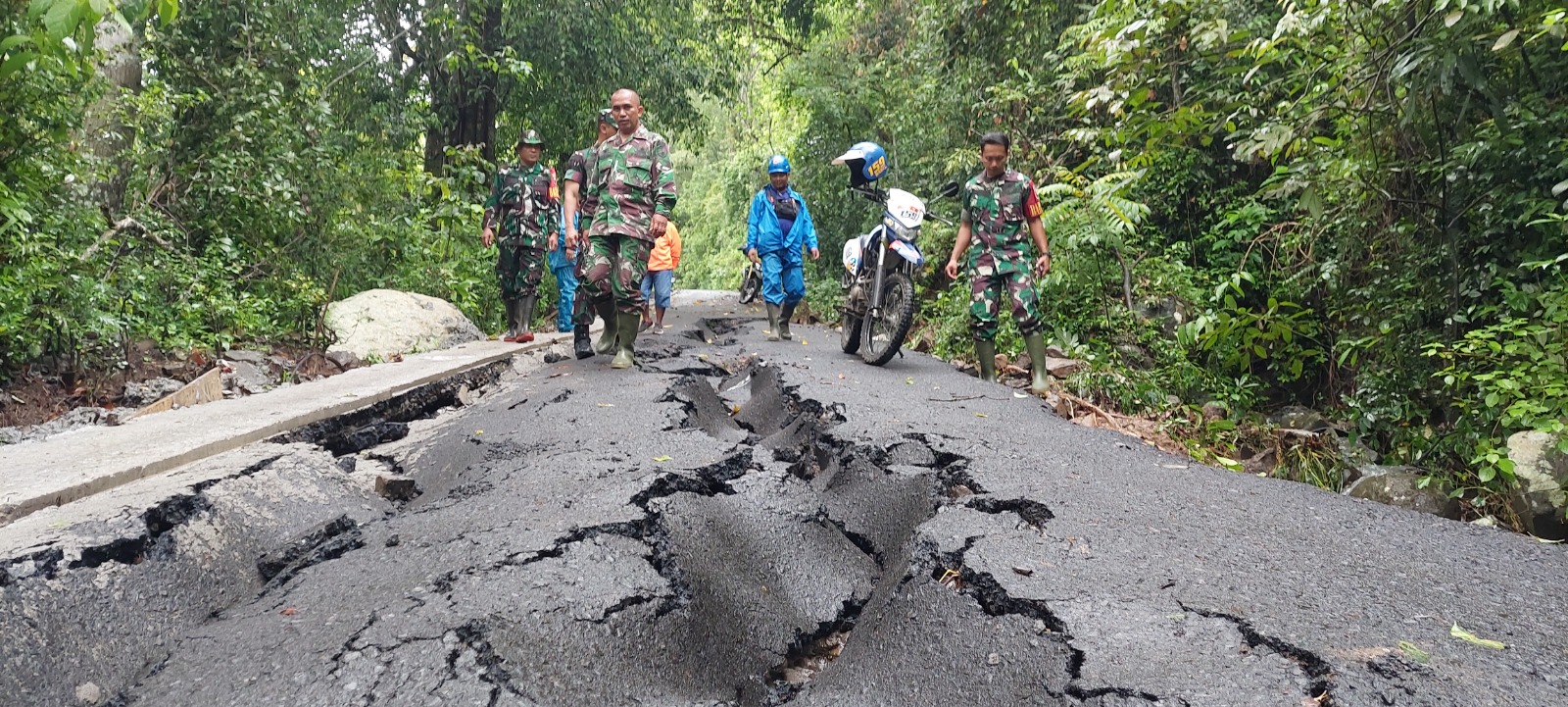 BERBAHAYA: Dandim 0824 Jember Letkol Arm Indra Andriansyah dan Muspika Tempurejo mengecek jalan ambles akibat tergerus air hujan, kemarin. (JUMAI/RJ)