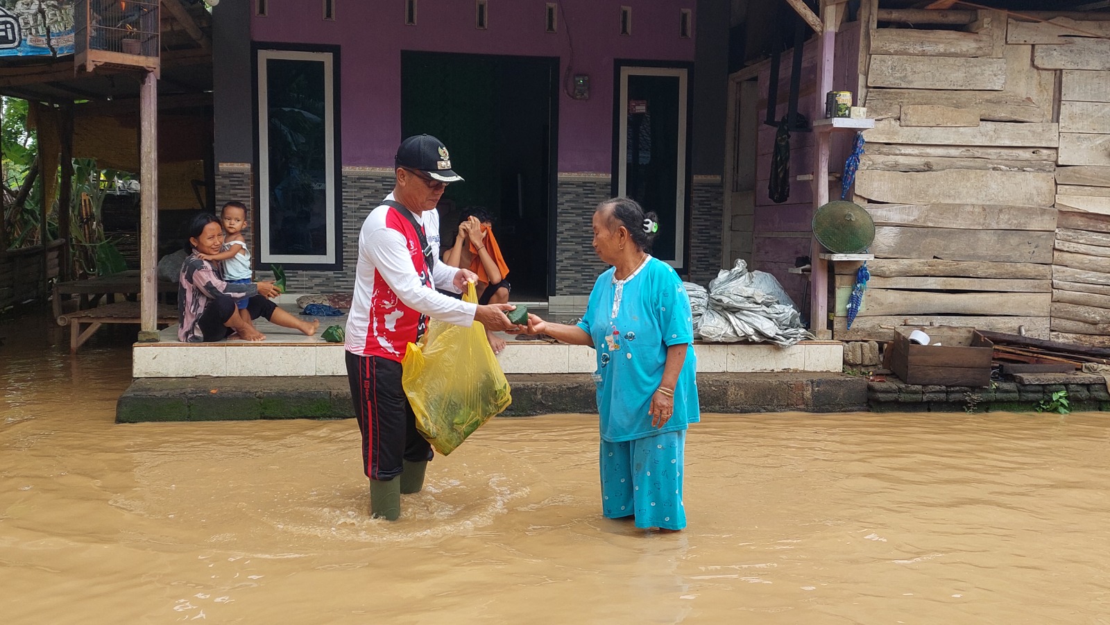 BAGI NASI BUNGKUS: Miseran, Kepala Desa Wonoasri, Kecamatan Tempurejo, bagi-bagi nasi bungkus kepada warganya. (JUMAI/RJ)