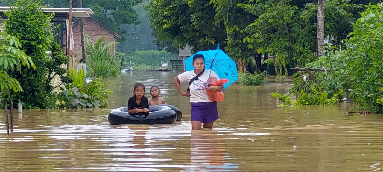 RUMAH TERDAMPAK BERTAMBAH: Warga keluar dari rumahnya yang kebanjiran akibat luapan sungai Curahnongko, di Dusun Kraton, Desa Wonoasri, Tempurejo Minggu (1/12). (JUMAI/RJ)