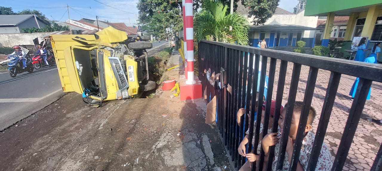 TERGULING: Truk Boks yang disopiri Agus, 25, warga Mojokerto terguling setelah menabrak pagar dan gapuron SDN Tanggul Wetan 01, Desa Tanggul Wetan, Kecamatan Tanggul, kemarin.