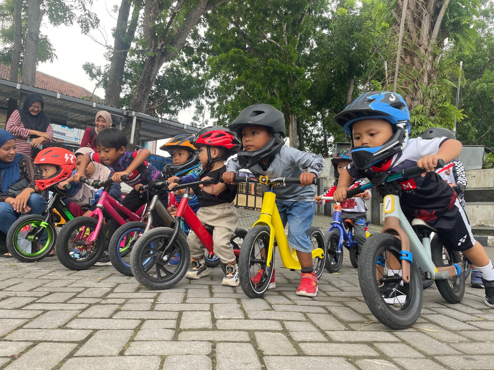SERU: Belasan anak-anak sedang asyik ikut olahraga push bike meski usianya masih belia.