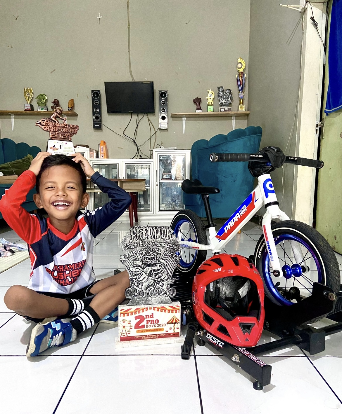 PAMER : Abidzar menujukkan piala saat mendapatkan podium satu olahraga push bike di Surabaya.