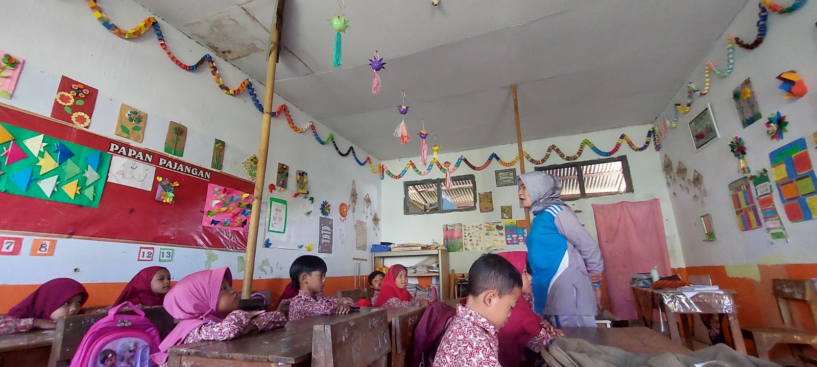 DIPASANG PENYANGGA: Ruang kelas 1 SDN Badean 04, Desa Badean, Kecamatan Bangsalsari, yang dipasang dua penyangga dari bambu agar plafon tidak ambruk, kemarin (19/12). (JUMAI/RJ)