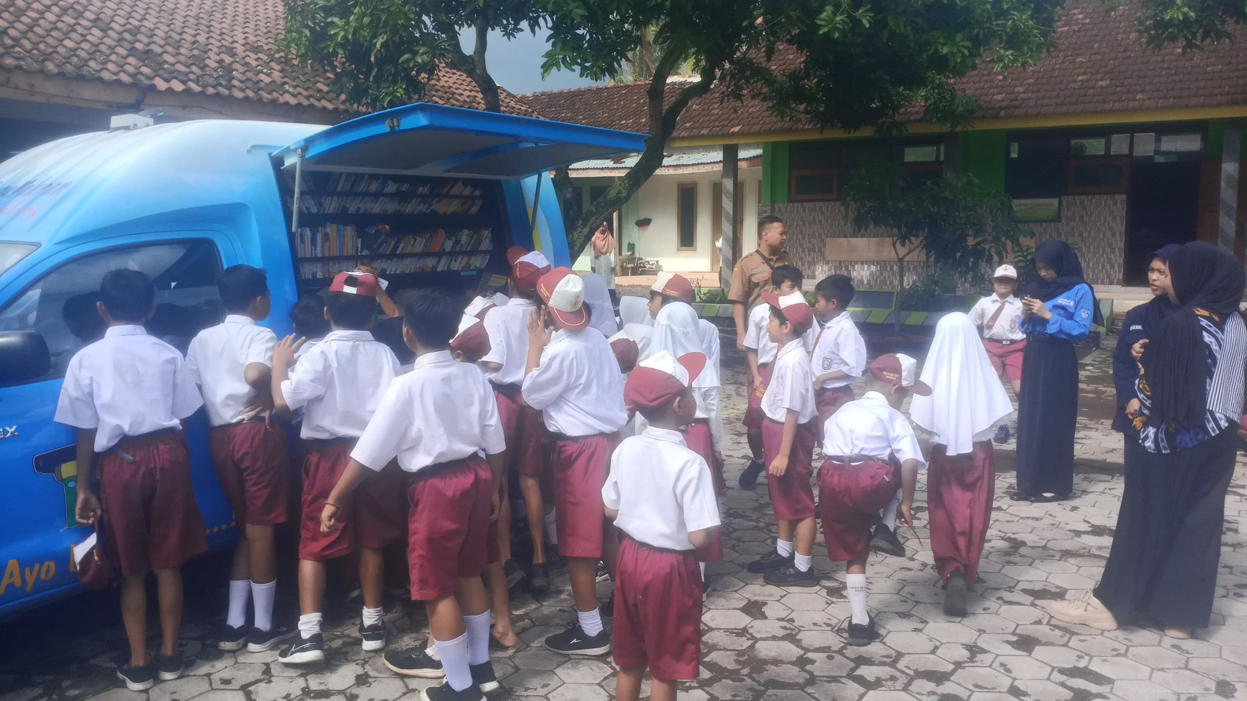 DISERBU SISWA: Mobil perpustakaan keliling dari Dispusip diserbu sejumlah siswa untuk mencari bahan bacaan.