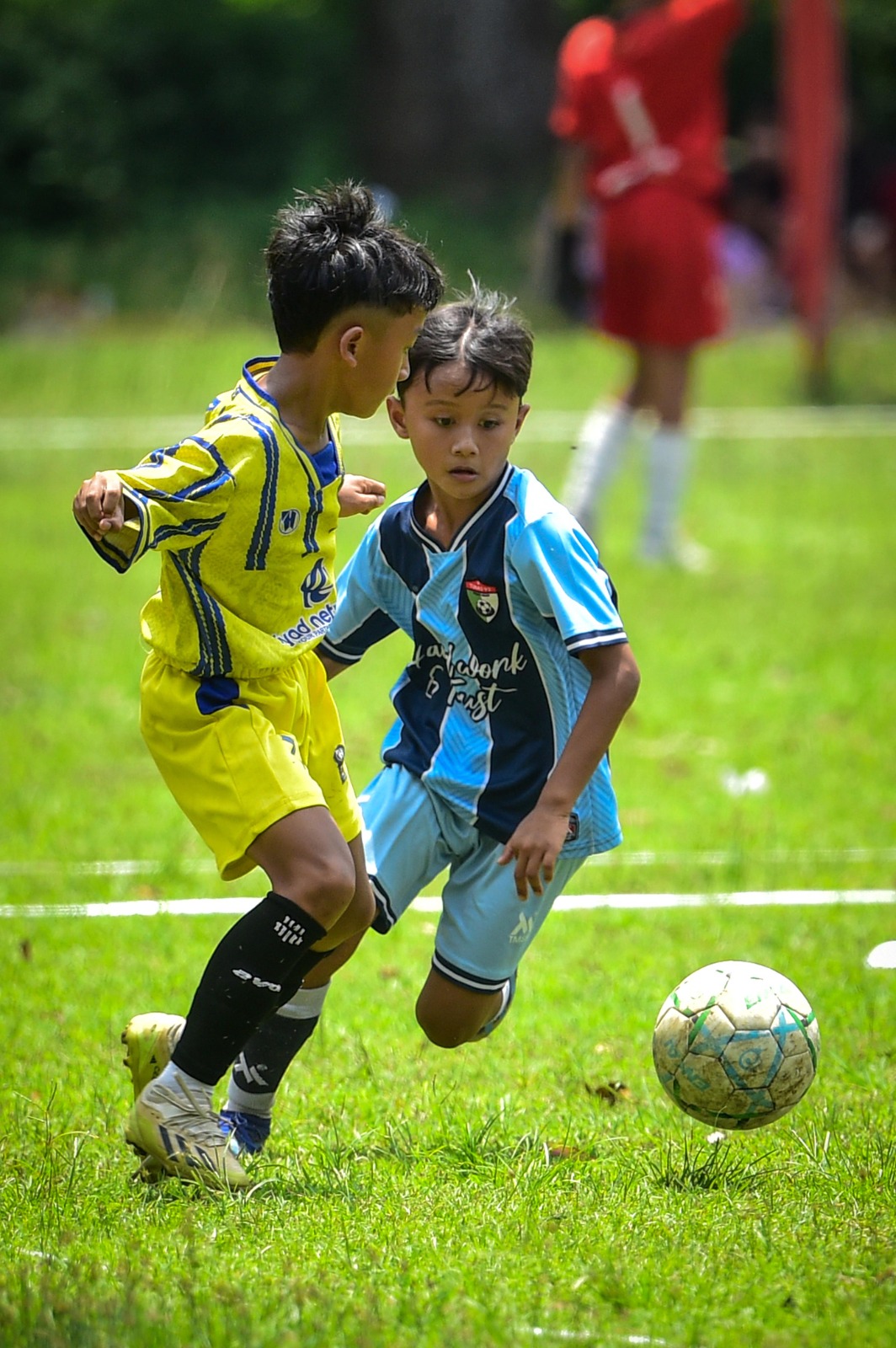 ADU SKILL: Tim JFoS U-10 (jersey biru) mencoba merebut bola dari pemain Tunas 92 Banyuwangi pada laga final Liga Anak Indonesia Regional Jember U-10 di Lapangan Secaba Rindam V Brawijaya, Minggu.
