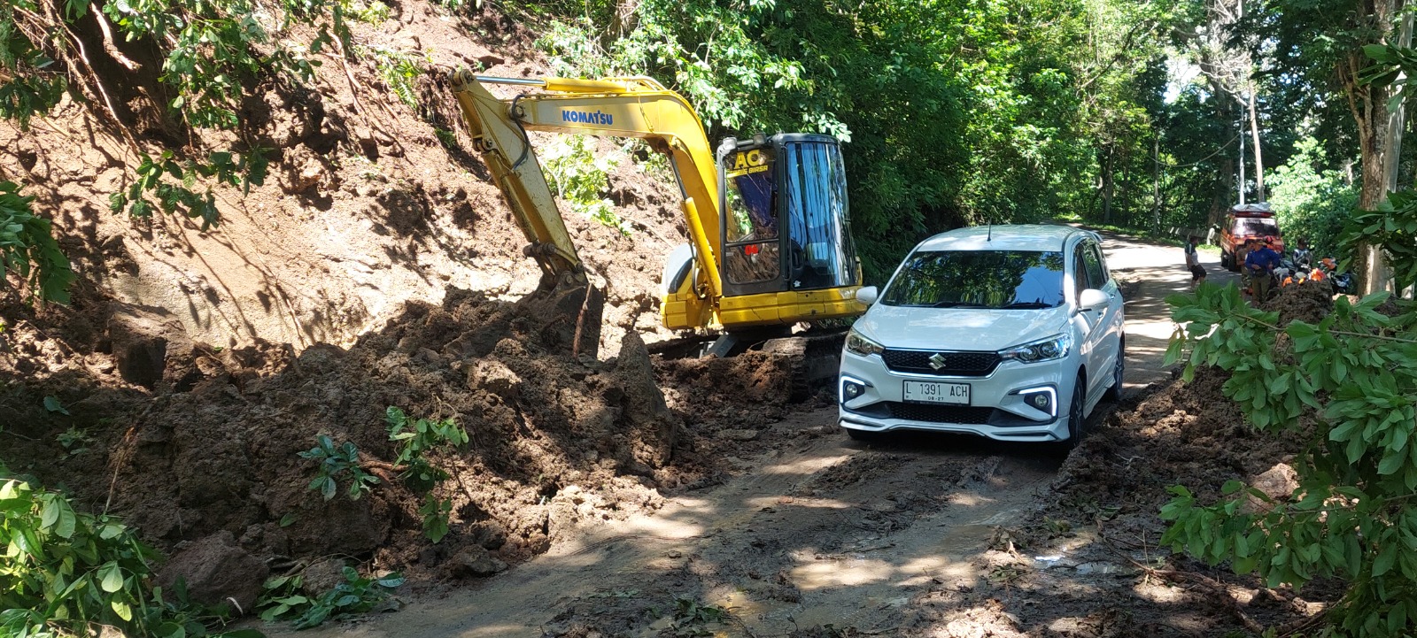 PROSES EVAKUASI: Tebing jalur menuju Pantai Papuma, Desa Lojejer, Kecamatan Wuluhan, longsor dan dibersihkan, Selasa (24/12). (JUMAI/RJ)