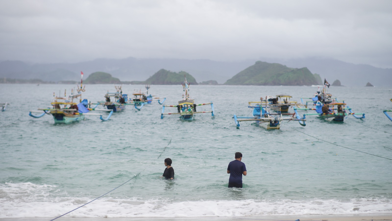 MENYENANGKAN: Sejumlah wisatawan asyik bermain air di bibir Pantai Papuma Jember.&nbsp; (YULIO/RJ)