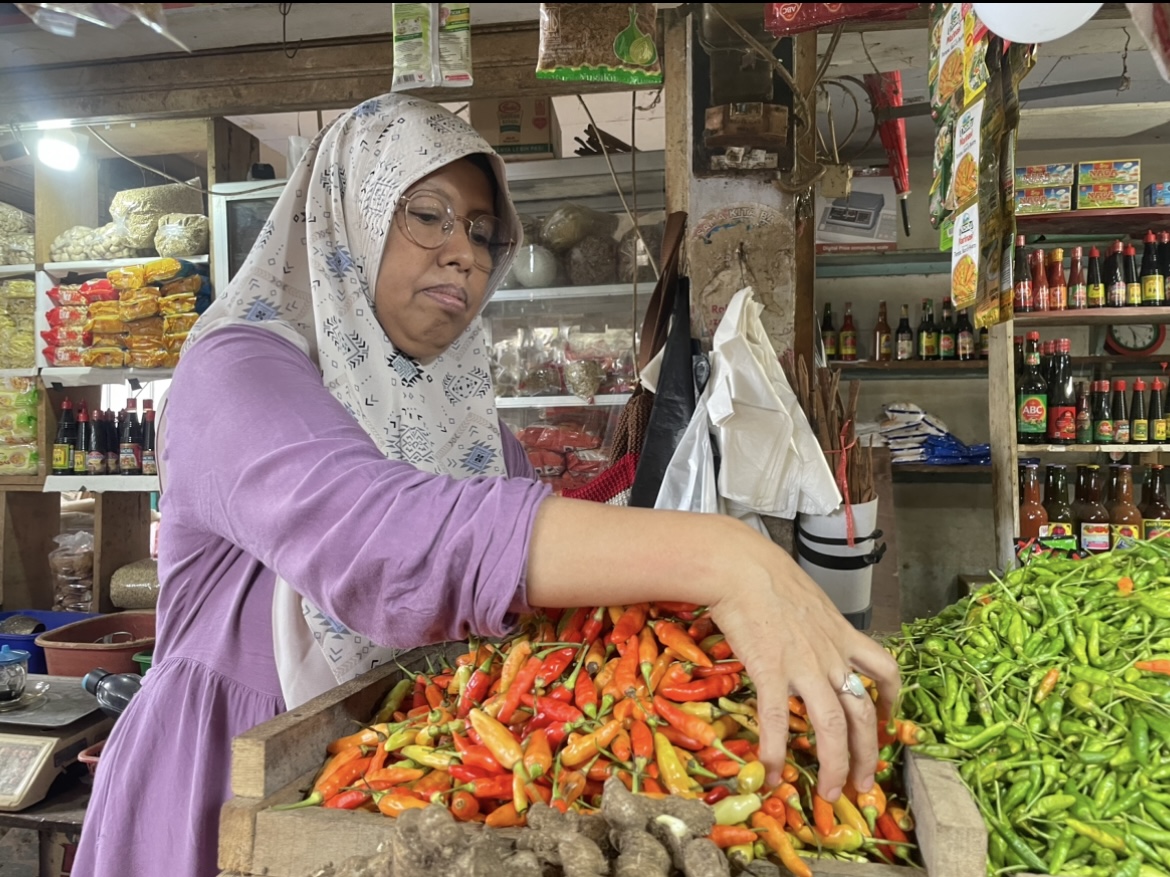 LESU: Salah satu pedagang di Pasar Baru Lumajang saat melayani pembeli, kemarin. (ADE APRYANIS/RAME)