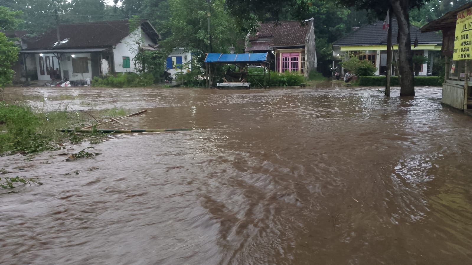 BANJIR: Luapan air sungai akibat tersumbat tumpukan material sampah dan kayu di jembatan sungai perbatasan Desa Sukorejo dan Desa Karangsono, Kecamatan Bangsalsari, Sabtu (18/1).  (BARET RESCUE)