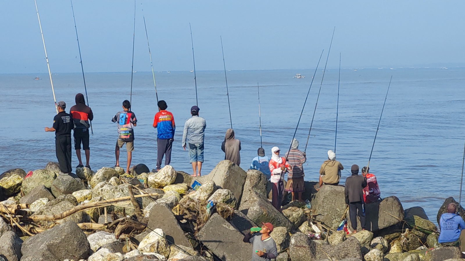 JADI LOKASI MANCING: Ambrolnya bagian ujung break water (pemecah ombak) kini menjadi lokasi favorit bagi para pemancing ikan. (JUMAI/RJ)