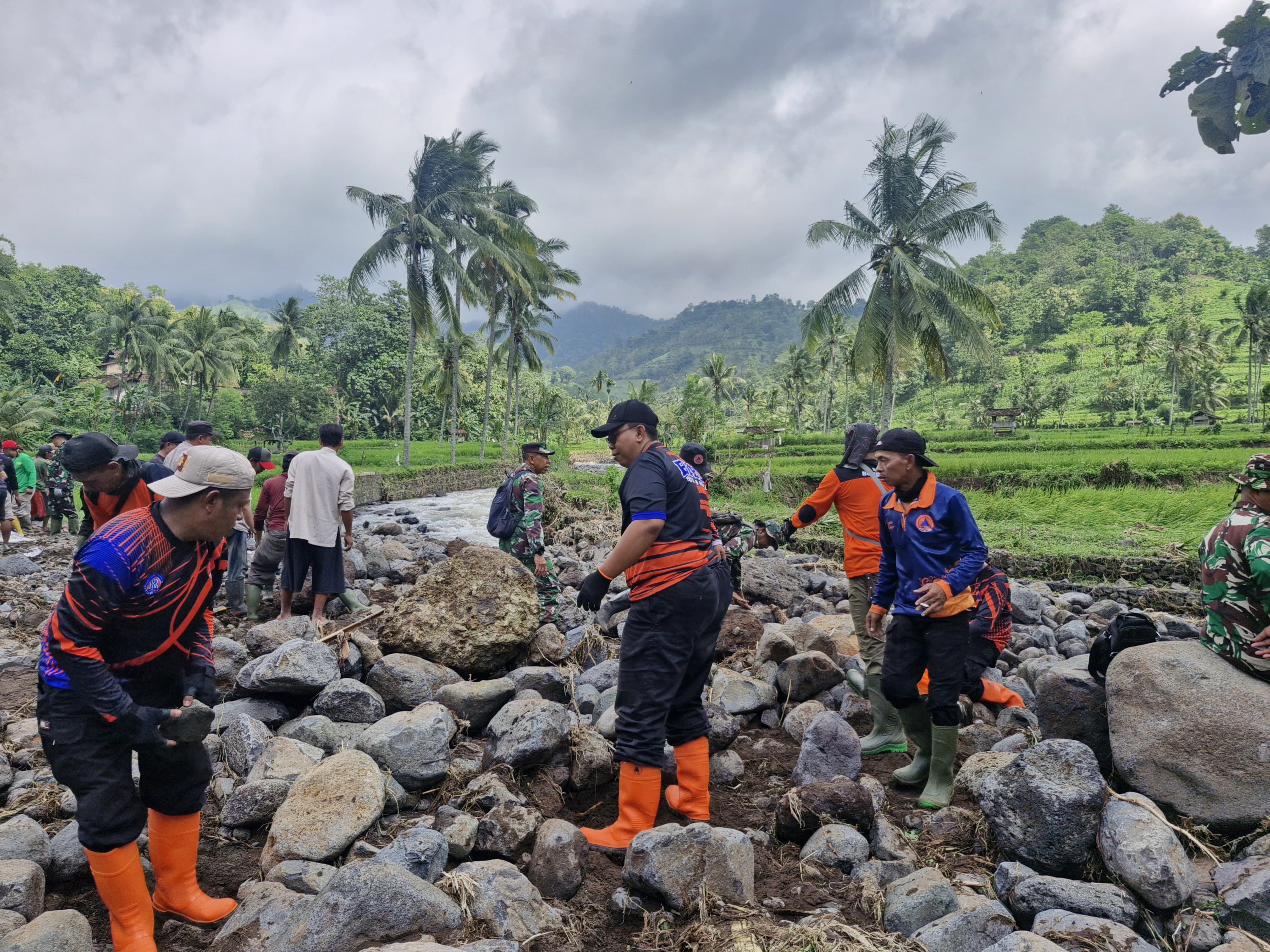 MEMBERSIHKAN: Sejumlah petugas saat melakukan evakuasi terharap pqra korban banjir, kemarin (5/2) di Desa Wonoboyo Kecamatan Klabang.