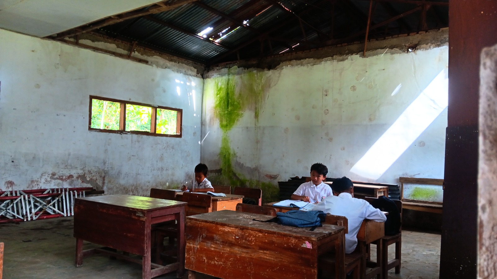 TETAP SEMANGAT: Siswa kelas 5 SDN Jambearum 2 melangsungkan aktivitas belajar di ruang kelas yang tidak layak pakai, kemarin.