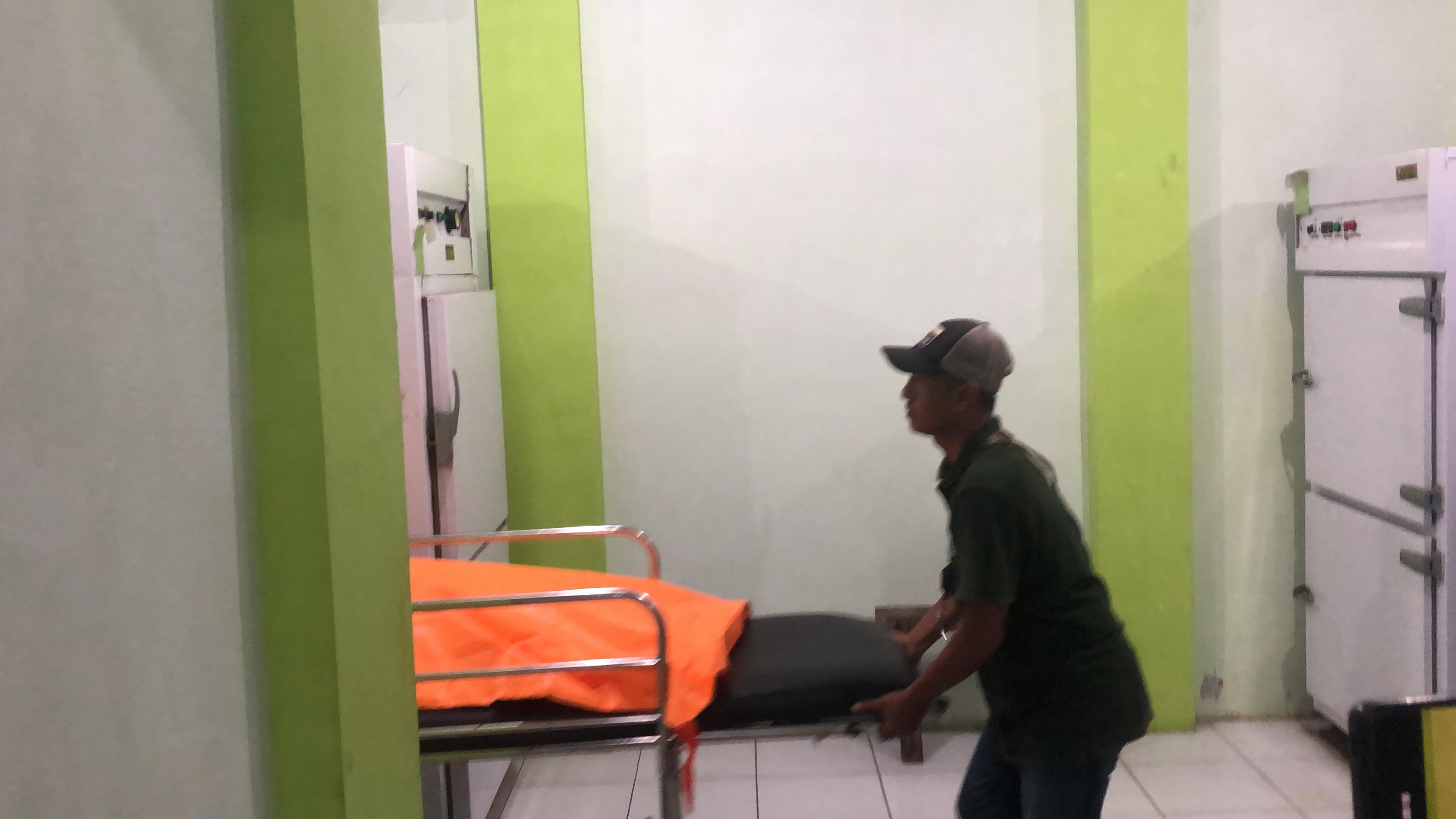 DITEMUKAN: Salah seorang petugas ketika membawa jenazah bocah cilik yang tewas di kebun kopi. (Yulio/RJ)