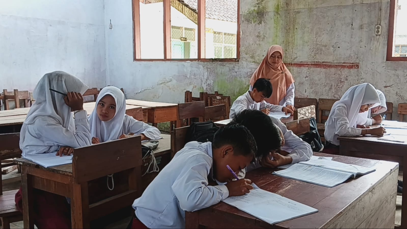 PENUH TANTANGAN: Guru di SDN Jambearum 02, Lutfiatul Jannah, tetap semangat mengajar siswa kelas 3.