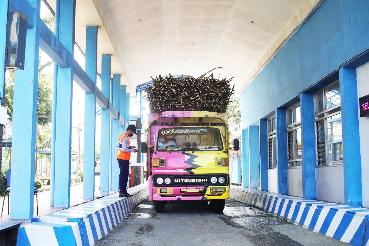 PANTAU: Petugas Unit Pelaksana Penimbangan Kendaraan Bermotor (UPPKB) Klakah saat mengecek berat kendaraan truk muatan tebu. (KOMINFO FOR RAME)