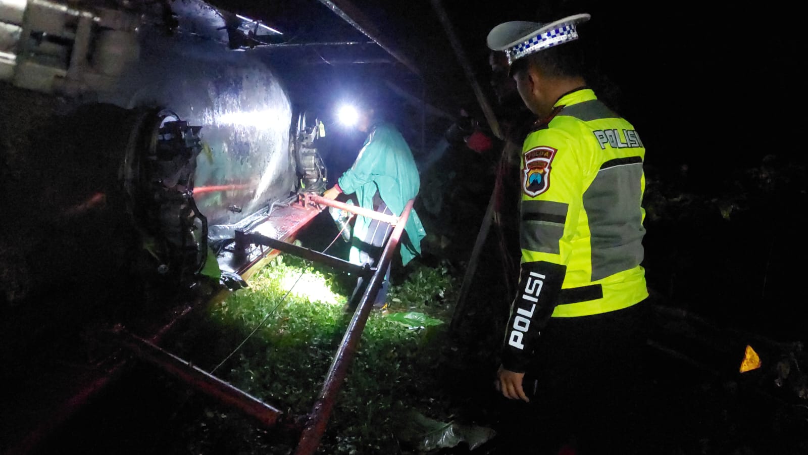 CEK KEBOCORAN: Pihak kepolisian memeriksa apakah ada kebocoran BBM di truk tangki pertamina yang mengalami laka tunggal. (JUMAI/RJ)