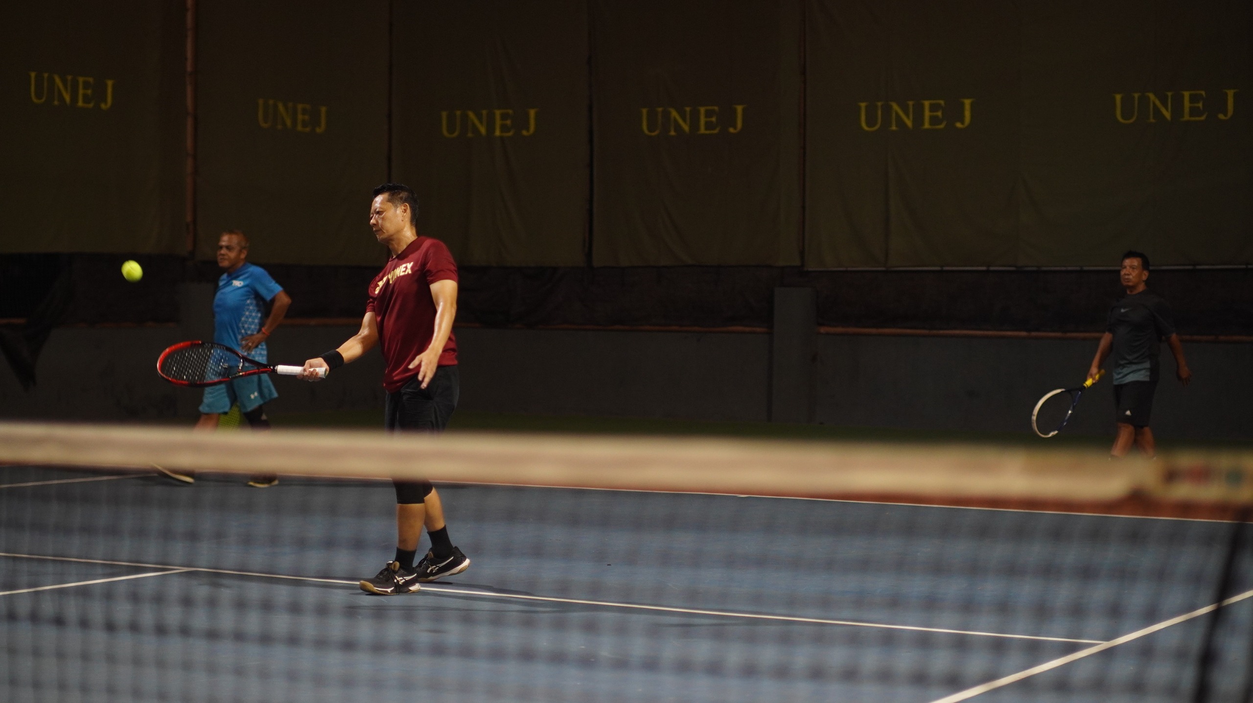 TAMPIL BUGAR: Di usia yang tak lagi muda Atlet Tenis Veteran, Kwang Kwang tampil lincah dalam kompetisi tenis three on three di lapangan tenis Universitas Jember, Selasa malam (26/2).