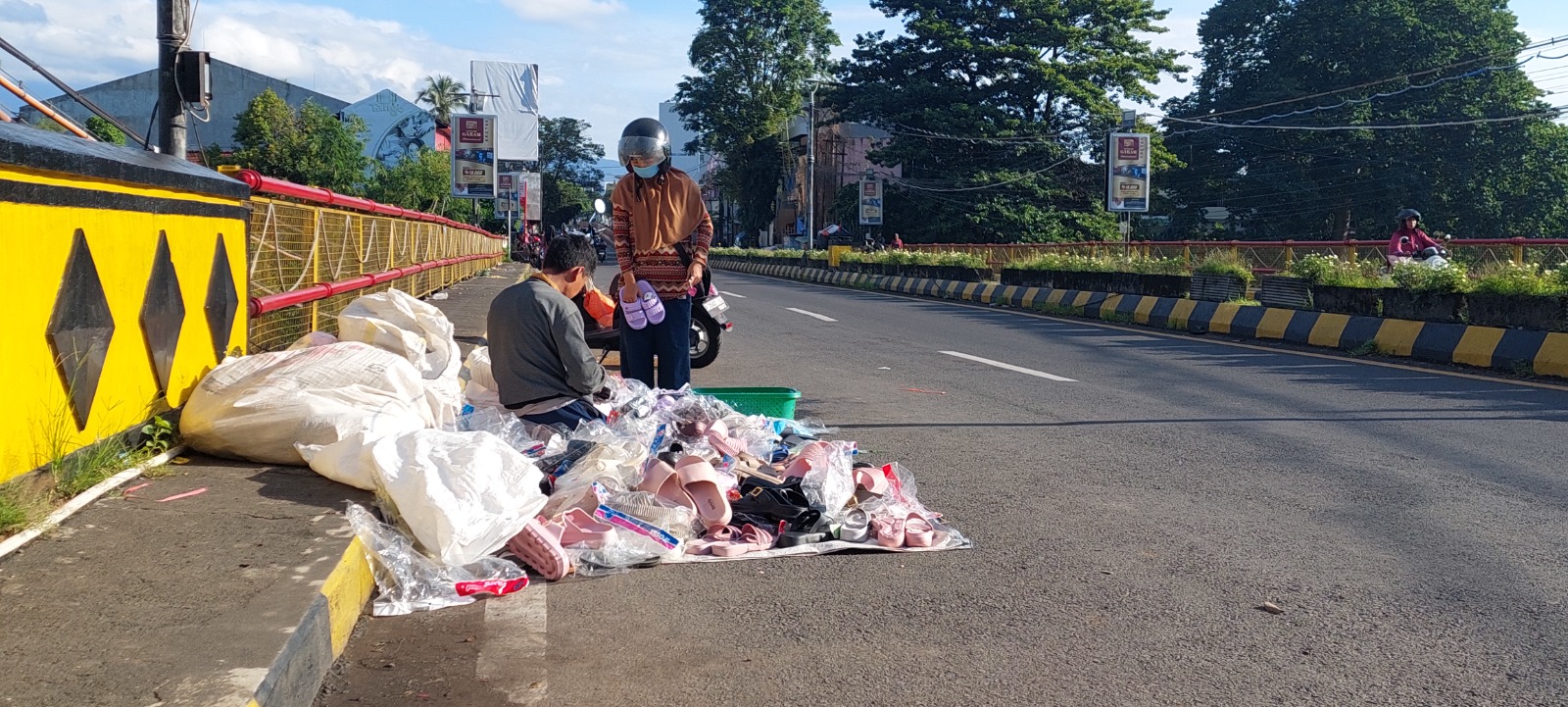 MASIH BERTAHAN: Salah satu pedagang kaki lima (PKL) di Pasar Kepatihan yang menempati jembatan untuk berjualan. Dirinya masih tetap berjualan meskipun jam sudah menunjukkan pukul 07.15 menit. (JUMAI)