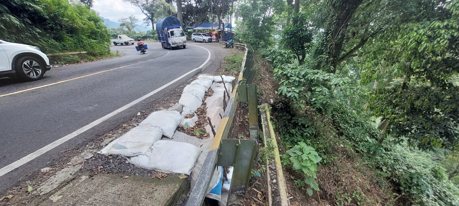 LONGSOR: Bibir jalan ditikungan mbah Singo Dusun Gumitir, Desa Sidomulyo, Kecamatan Silo yang longsor dipasang dengan zak diisi tanah