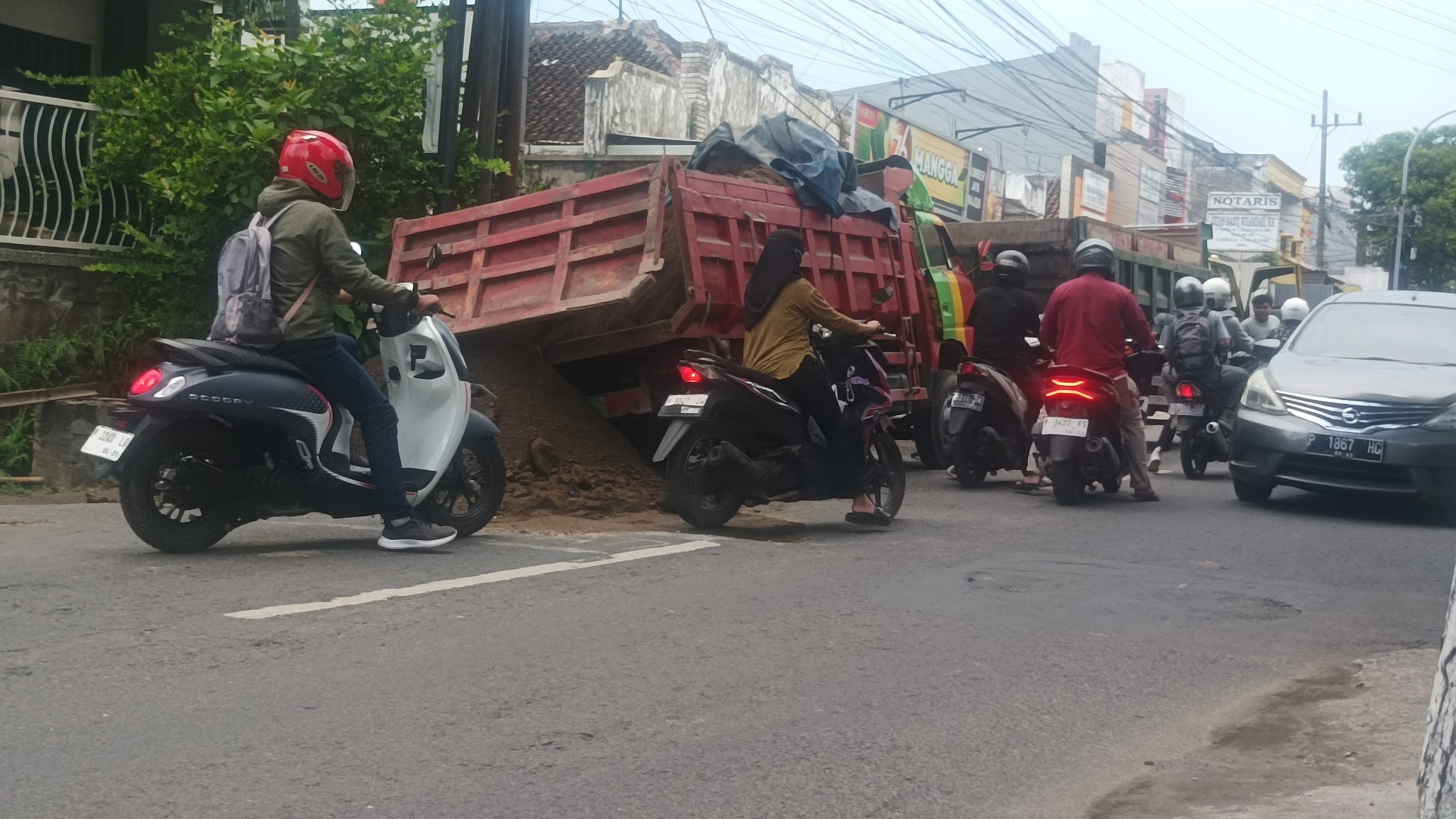 BERHASIL DIEVAKUASI: Dump truck bermuatan pasir gumuk terjebak di jalan ambles, Jalan Karimata, Kelurahan/Kecamatan Sumbersari, akibat gorong-gorong jebol, kemarin.
