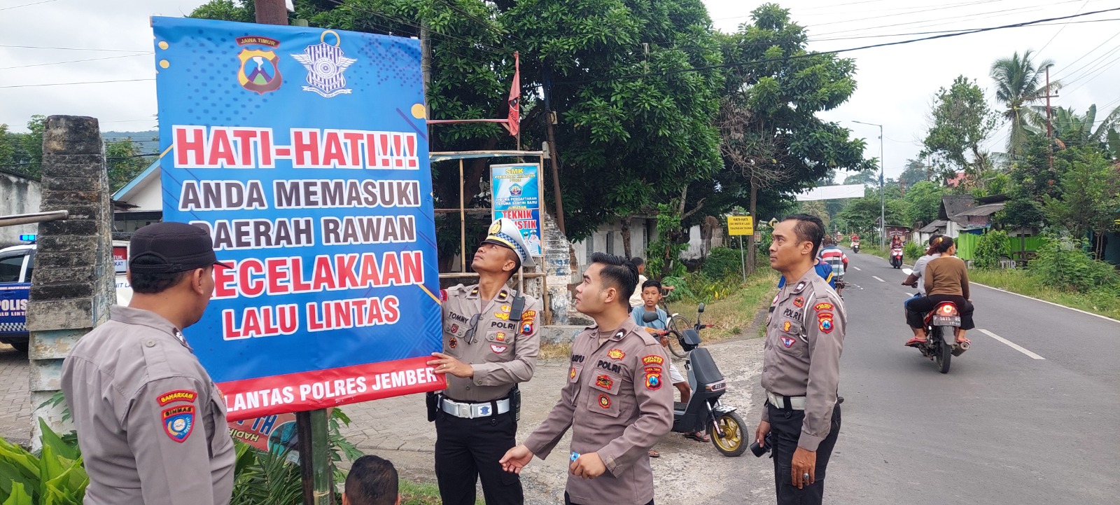 DEMI KESELAMATAN: Kanit Lakalantas Polres Jember Ipda Tommy Nur Alamsyah bersama anggota Polsek Ambulu saat memasang rambu imbauan rawan kecelakaan di Desa Sabrang, Kecamatan Ambulu, Rabu (19/3).