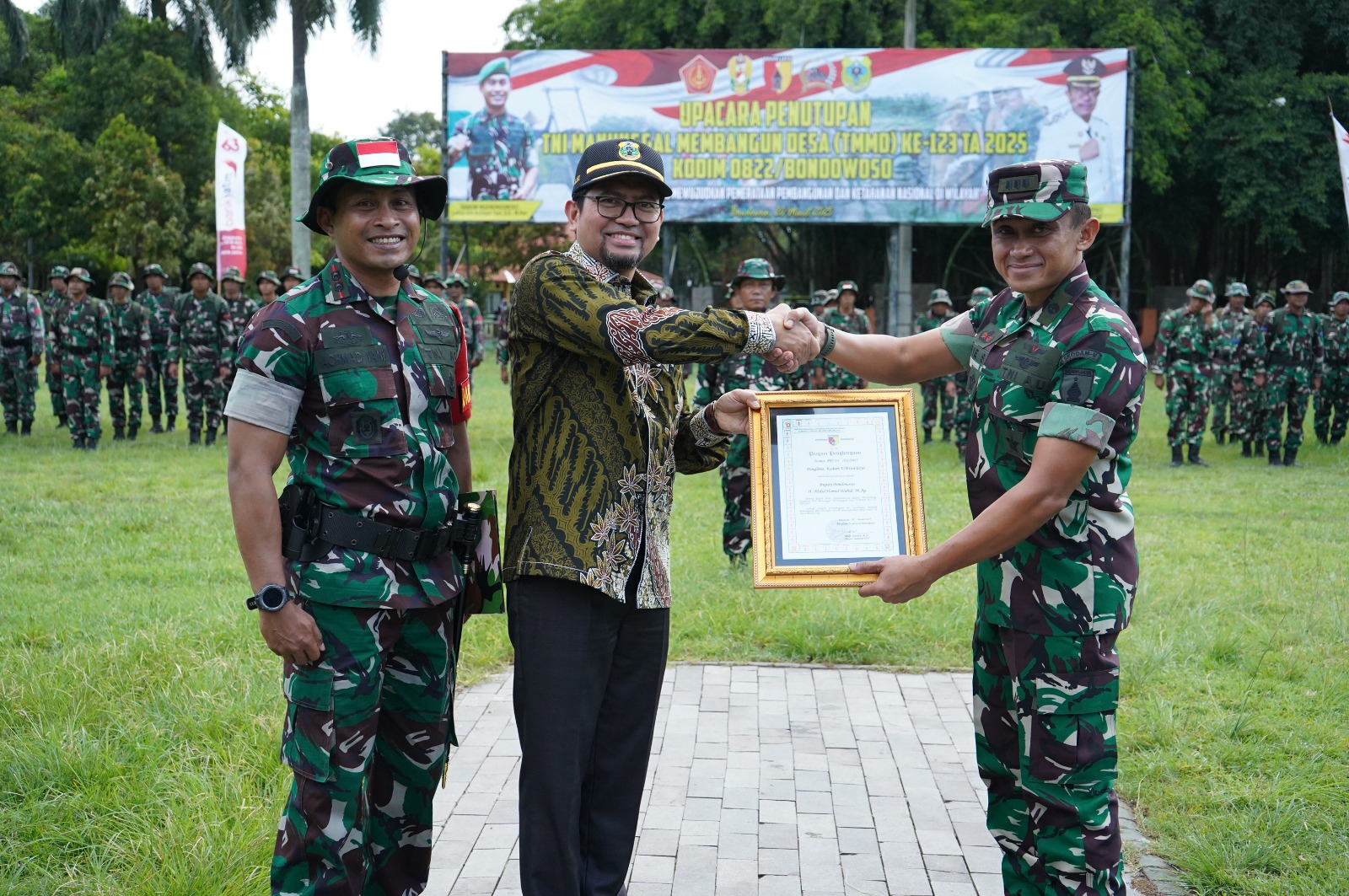 TERIMA KASIH: Perwira Liaison Officer TNI-AU Kodam V/Brawijaya Kolonel Teknik Arie Santoso memberikan piagam penghargaan kepada Pj Sekda Fathur Rozi mewakili Bupati Bondowoso H. Abdul Hamid Wahid MAg