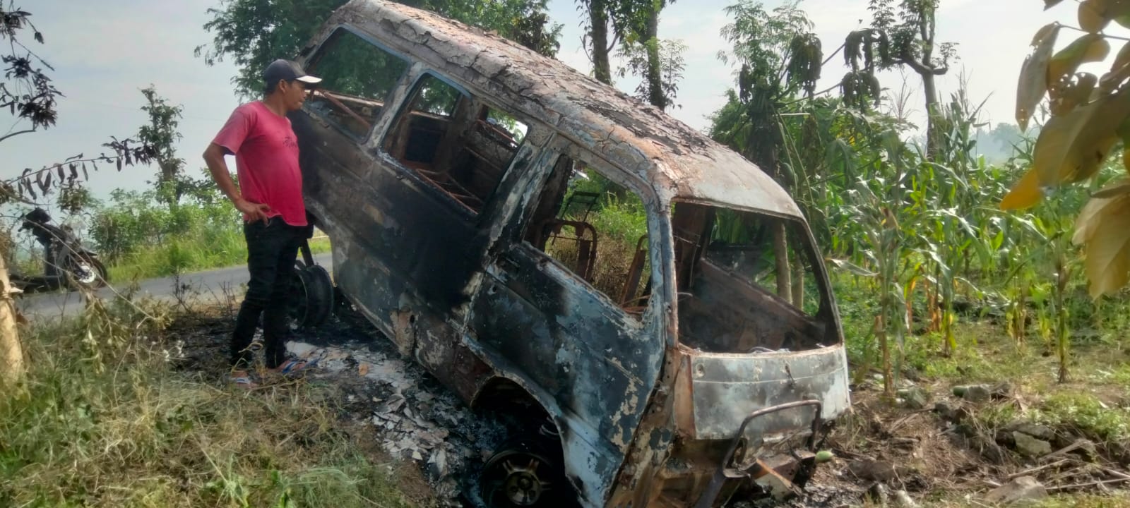 TINGGAL RANGKA: Mobil Daihatsu P 1065 MI yang diduga milik pelaku dibakar massa hingga tinggal rangkanya