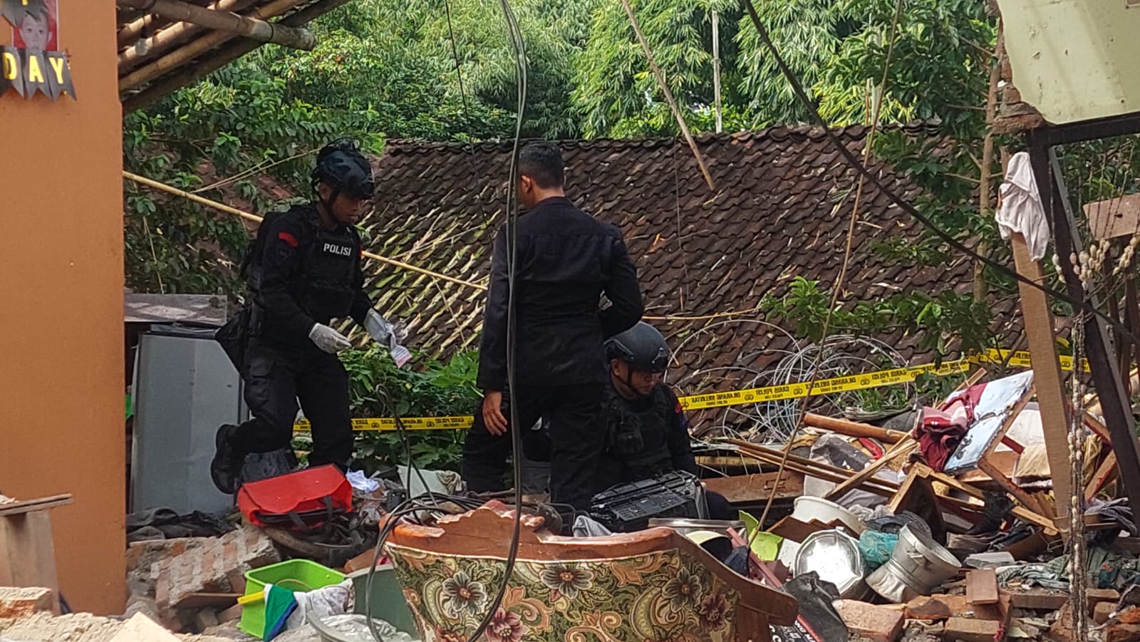 DATANGI LOKASI: Gegana Satbrimob Polda Jatim saat melakukan olah Tempat Kejadian Perkara (TKP) ledakan petasan di rumah Nur Imam Gozali, 45 warga kelurahan Antirogo, Kecamatan Sumbersari. (JUMAI/RJ)