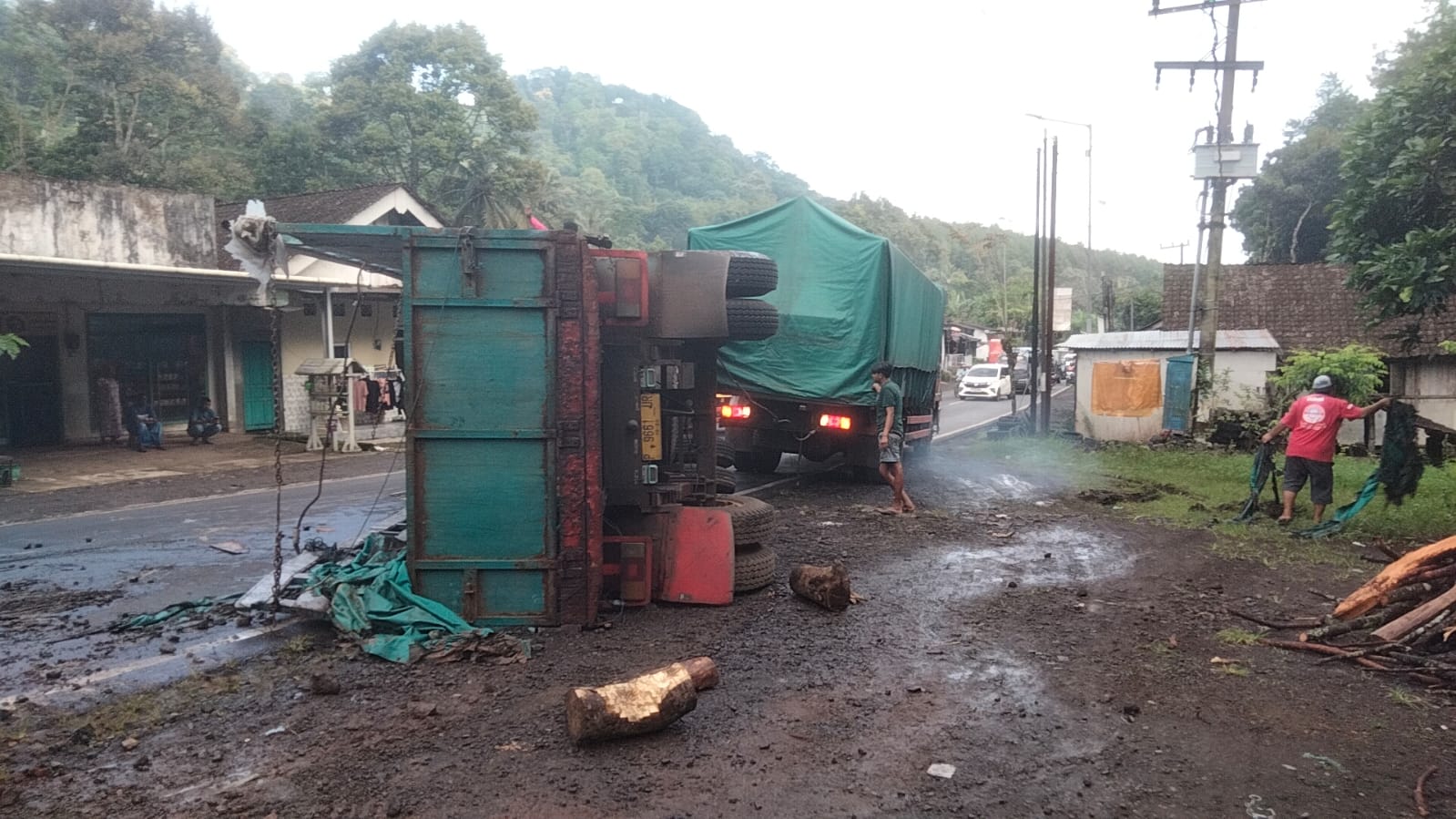 PROSES EVAKUASI: Bagian gandengan yang terguling di jalan Raya Jember &ndash; Banyuwangi, Desa Sidomulyo, Silo dalam proses evakuasi menggunakan truk dengan cara ditarik.