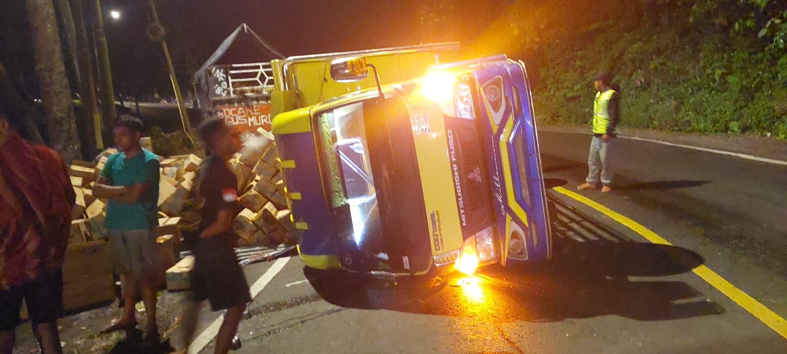 ADA KORBAN LAGI: Sebuah truk Disel N 8761 UZ dengan muatan minyak goreng terguling di tikungan mbah Singo, KM 36.800 Dusun Gumitir, Desa Sidomulyo, Kecamatan Silo Rabo (23/4) malam. (JUMAI/RJ)