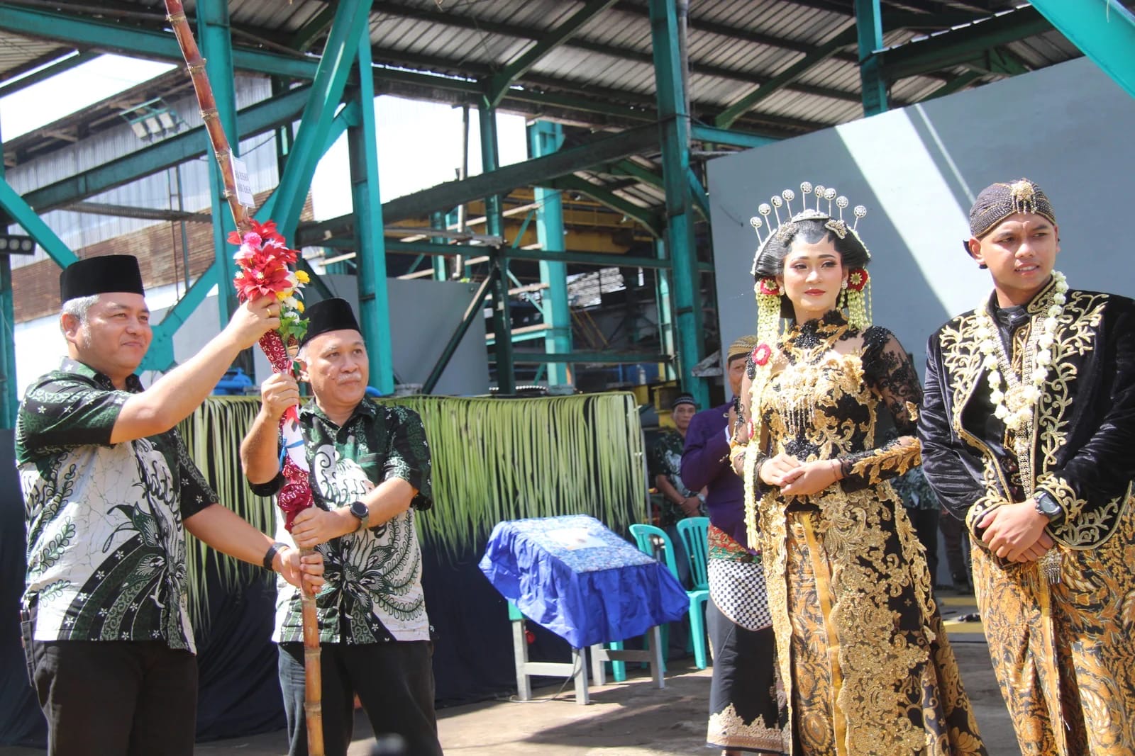 SERAHKAN: Prosesi serah terima tebu manten yang secara simbolis dilemparkan ke mesin penggiling Pabrik Gula Jatiroto, sebagai penanda awal musim giling. (ATIEQSON MAR IQBAL/RAME)