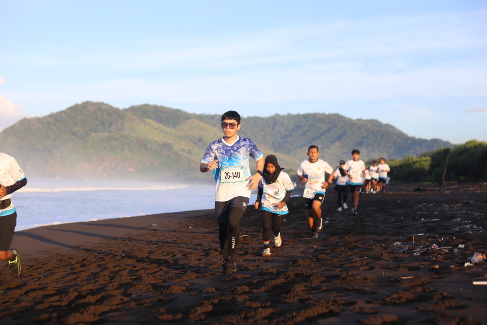SEMANGAT: Para runner Watu Ulo Reborn Beach Run 2025 saat baru di lepas masih berjalan bersama. Namun, ketangguhannya diuji melewati pesisir pantai Watu Ulo.(Dwi Siswanto/RJ)