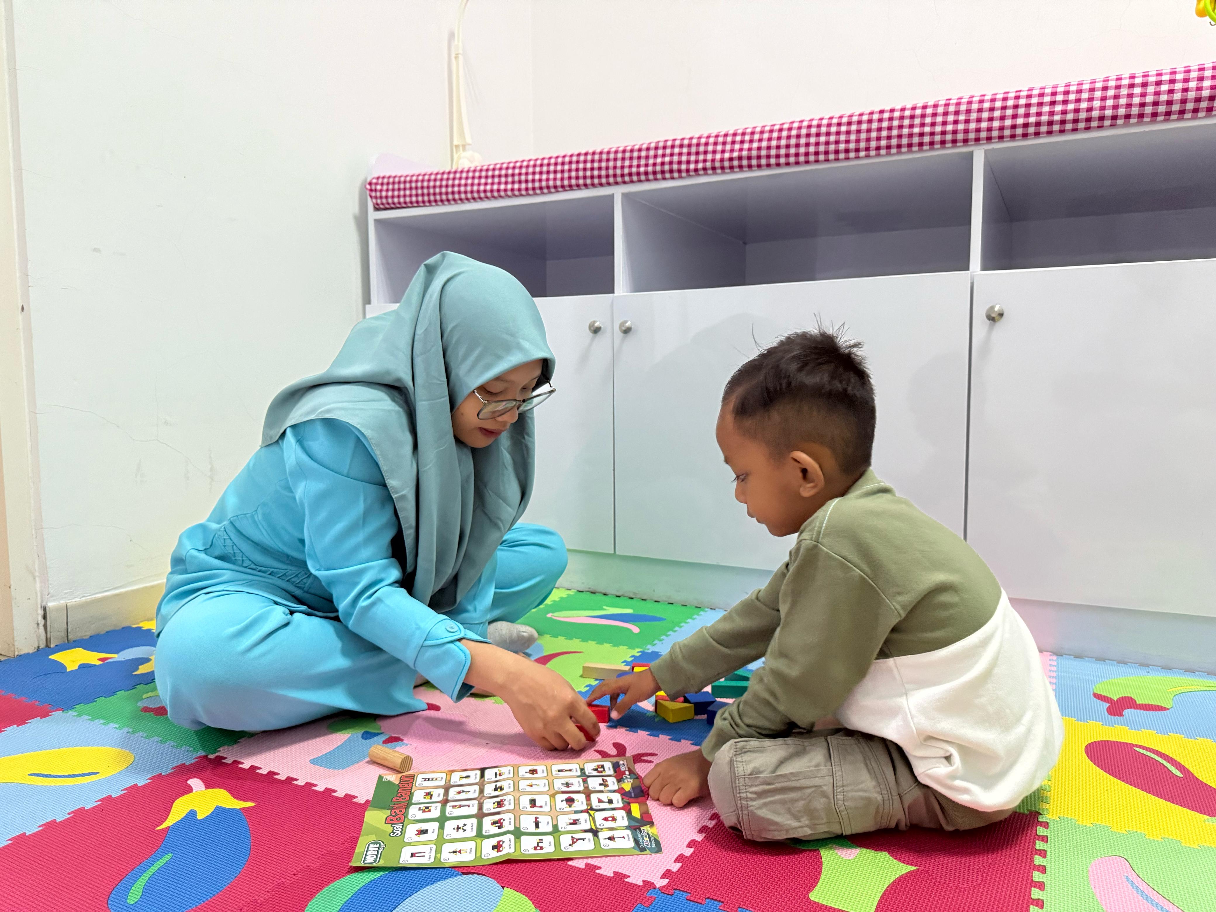 PELAYANAN PRIMA: Nakes RSBS Jember saat melayani anak kecil yang ikut terapi wicara.