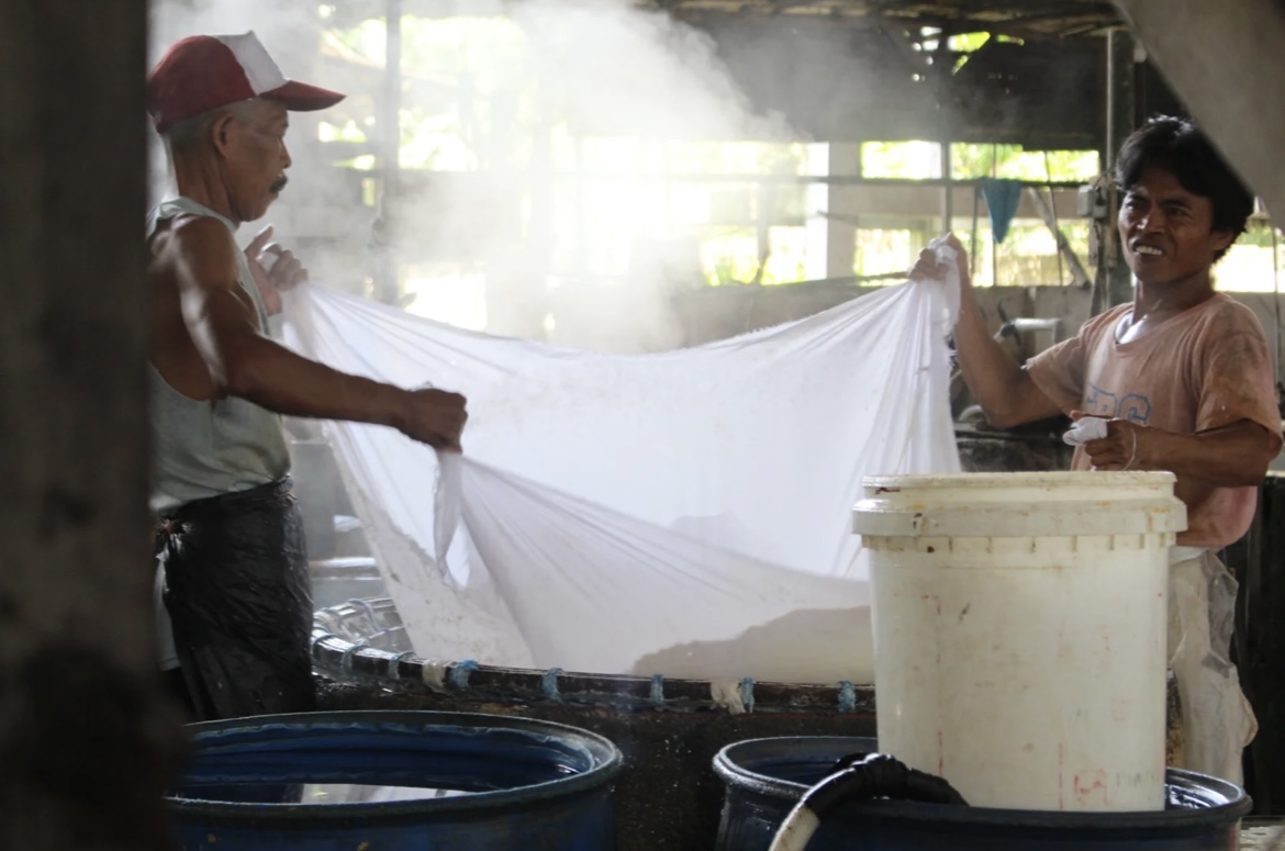BERSEMANGAT: Sejumlah pekerja pabrik tahu kurma Bondowoso tengah mengolah kedelai menjadi tahu menggunakan alat sederhana. (ILHAM WAHYUDI/RADAR IJEN )