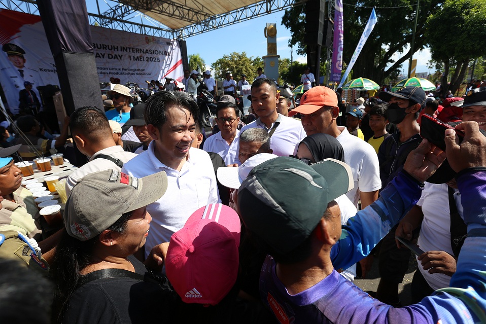 TEMUI MASYARAKAT: Bupati Fawait foto bersama ribuan peserta jalan sehat guna memperingati Hari Buruh 1 Mei, di sekitar kawasan Jember kota, Kamis (1/5). (YULIO FA/RADAR JEMBER)