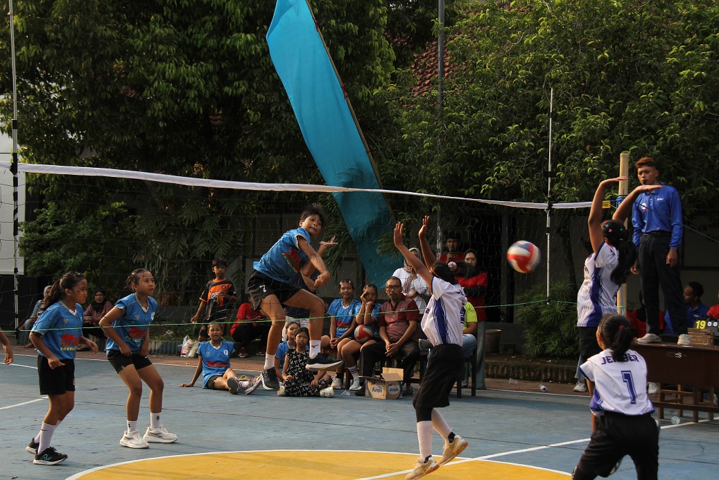 BERSAING: Siswa SDN Gebang 04 (jersey biru), Kecamatan Patrang, melawan SDN Kaliwates 02, Kecamatan Kaliwates, dalam event bola voli Spasa Cup 2025, di lapangan voli Spasa Jember. (JUMAI/RADAR JEMBER)