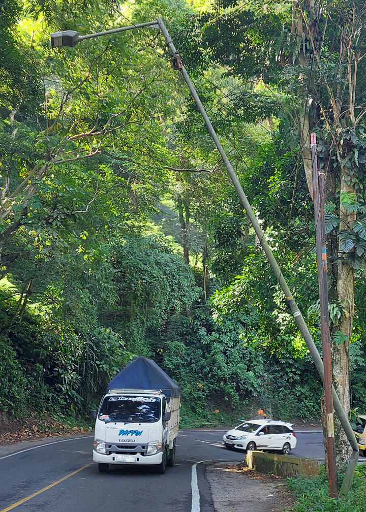 MEMBAHAYAKAN: Kondisi tiang PJU di jalur Gumitir, Dusun Gumitir, Desa Sidomulyo, Kecamatan Silo yang kondisinya miring setelah tertabrak truk yang terjung ke jurang beberapa bulan lalu. (JUMAI/RJ)