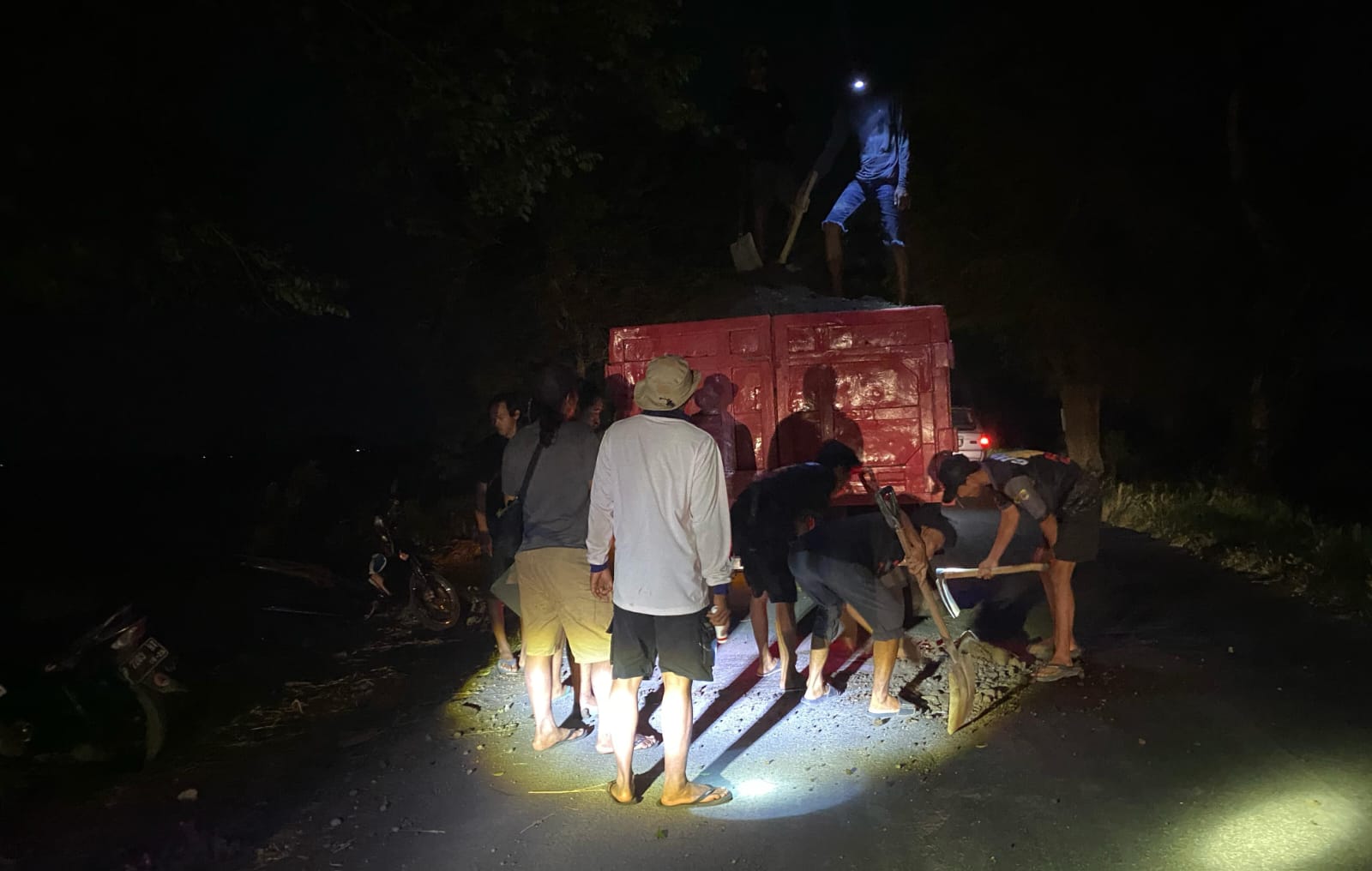 AKSI KEDUA: Puluhan warga Desa Kencong saat melakukan perbaikan jalan rusak dengan menggunakan pasir dicampur semen dijalan jurusan Desa Kencong dengan Desa Pondokjoyo, Kecamatan Semboro