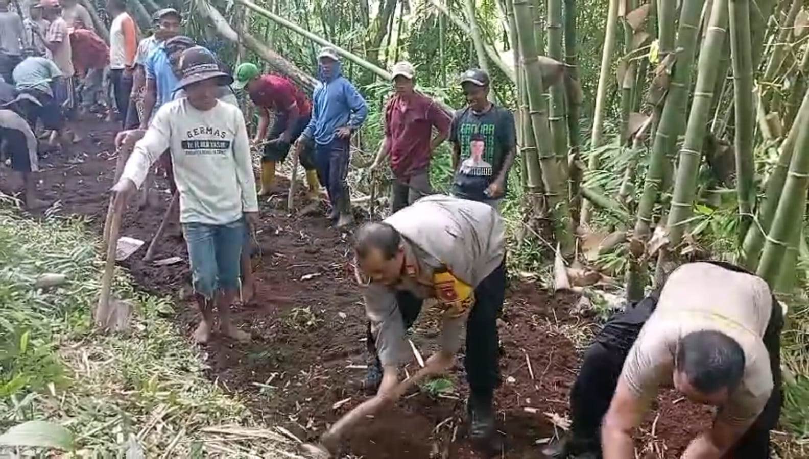 BUKA AKSES: Kapolsek Arjasa AKP Subagiyo bersama anggotanya serta warga Desa Kamal dan Desa Arjasa kerja bakti membuka akses jalan, Minggu (4/5). (POLSEK ARJASA/RADAR JEMBER)