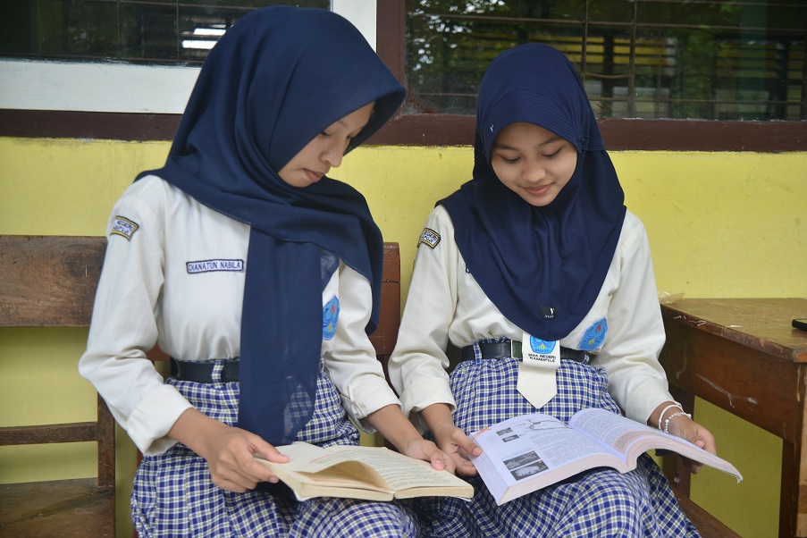 SANTAI: Siswa SMAN Rambipuji mengisi waktu kosong saat jam istirahat dengan membaca buku. (M ADHI SURYA/RADAR JEMBER)