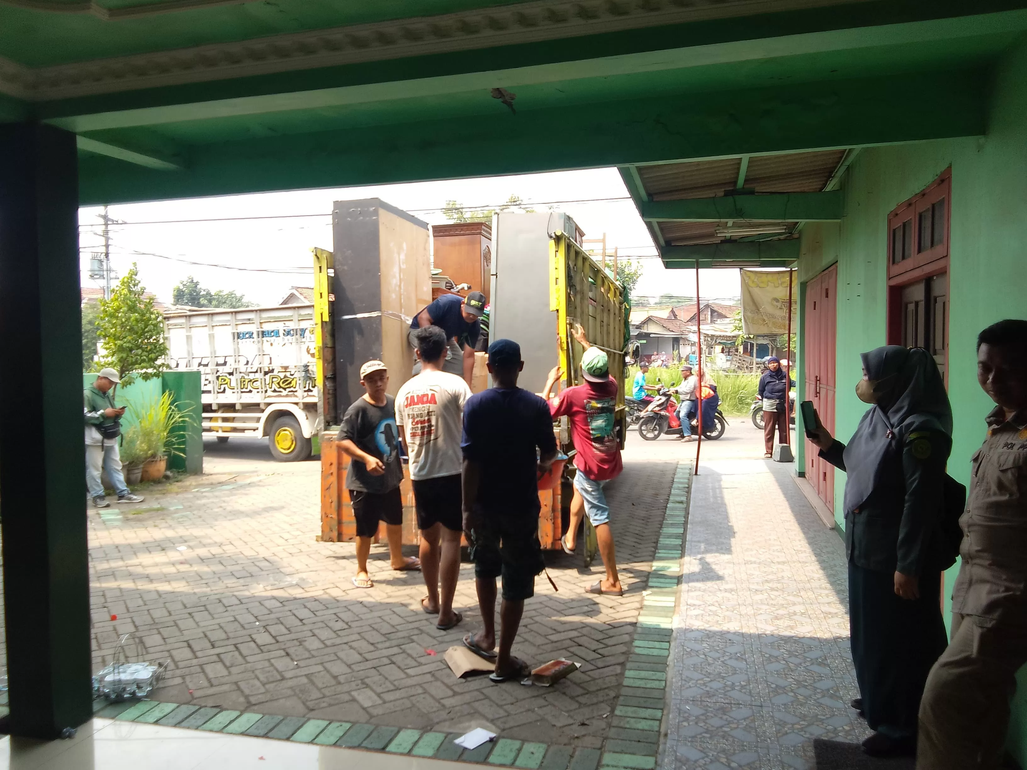 PENGOSONGAN: Petugas juru sita mengeluarkan barang yang ada di dalam rumah, Selasa (6/5). (DIKY PUTRA SANSIRI/RADAR SIDOARJO)