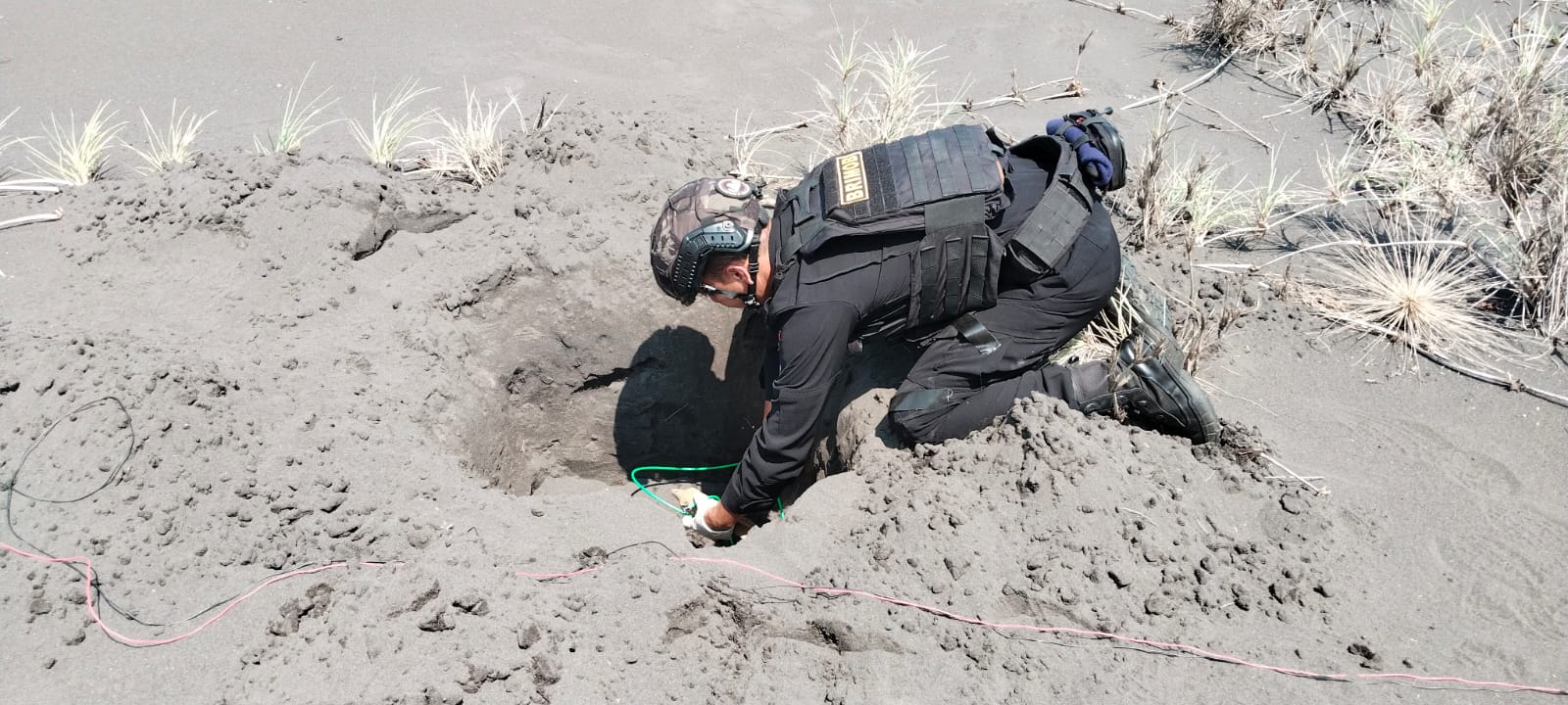 AKHIRNYA DILEDAKKAN: Anggota penjinak bom (jibom) Polda Jatim bersiap meledakkan mortir di pesisir pantai Gumuk Garinten, Desa Paseban, Kencong, Jember, Rabu (14/5/2025). (Polsek Kencong/Radar Jember)