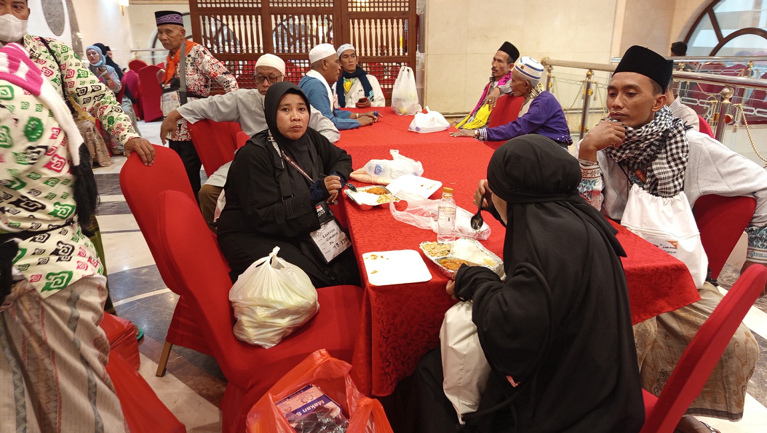 MAKAN SIANG: Sejumlah jemaah kloter 32 asal Jember menunggu persiapan makan siang setelah melakukan kegiatan tur di berbagai tempat, kemarin (14/5/2025). (MAHFIT)