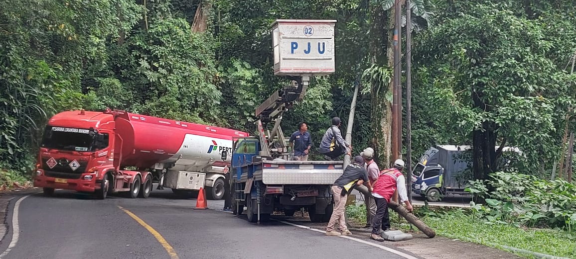 AKHIRNYA DIGANTI: Personil dari Dinas PU Cipta Karya Kabupaten Jember akhirnya mengganti tiang pju yang ada di KM 36.00, Dusun Gumitir, Desa Sidomulyo, Kecamatan Silo pada Rabu (14/5). (Jumai/RJ)